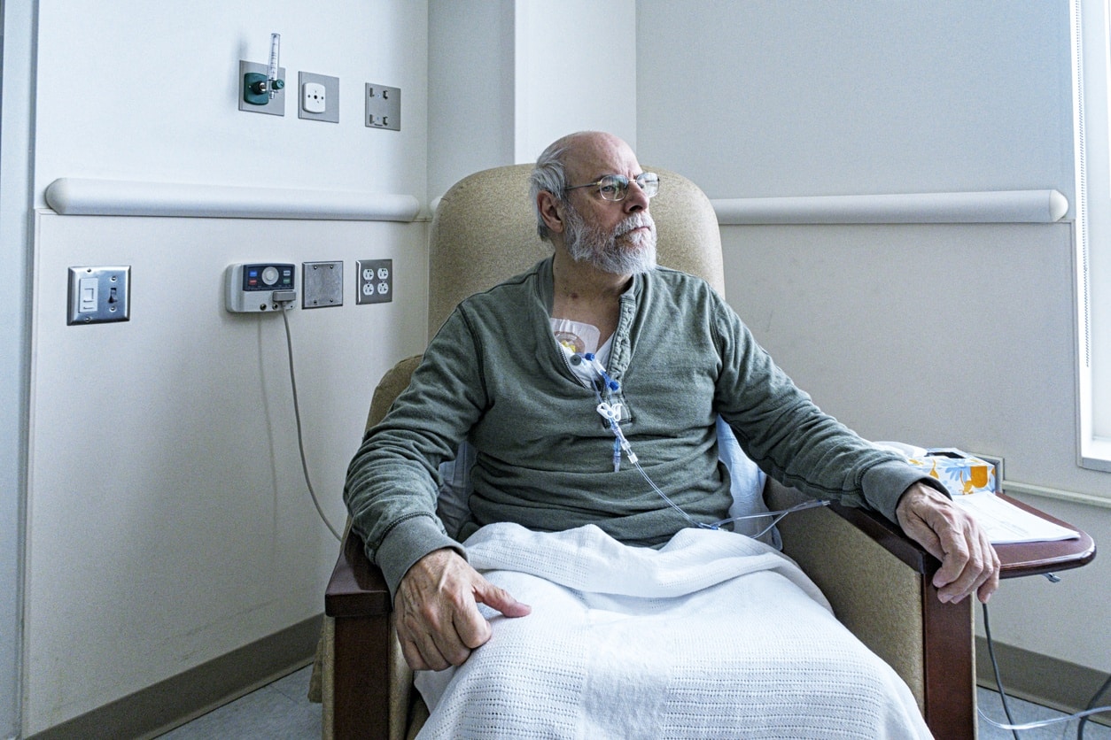 Man sitting in a hospital chair receiving a chemo infusion discussing What to Expect During Chemotherapy
